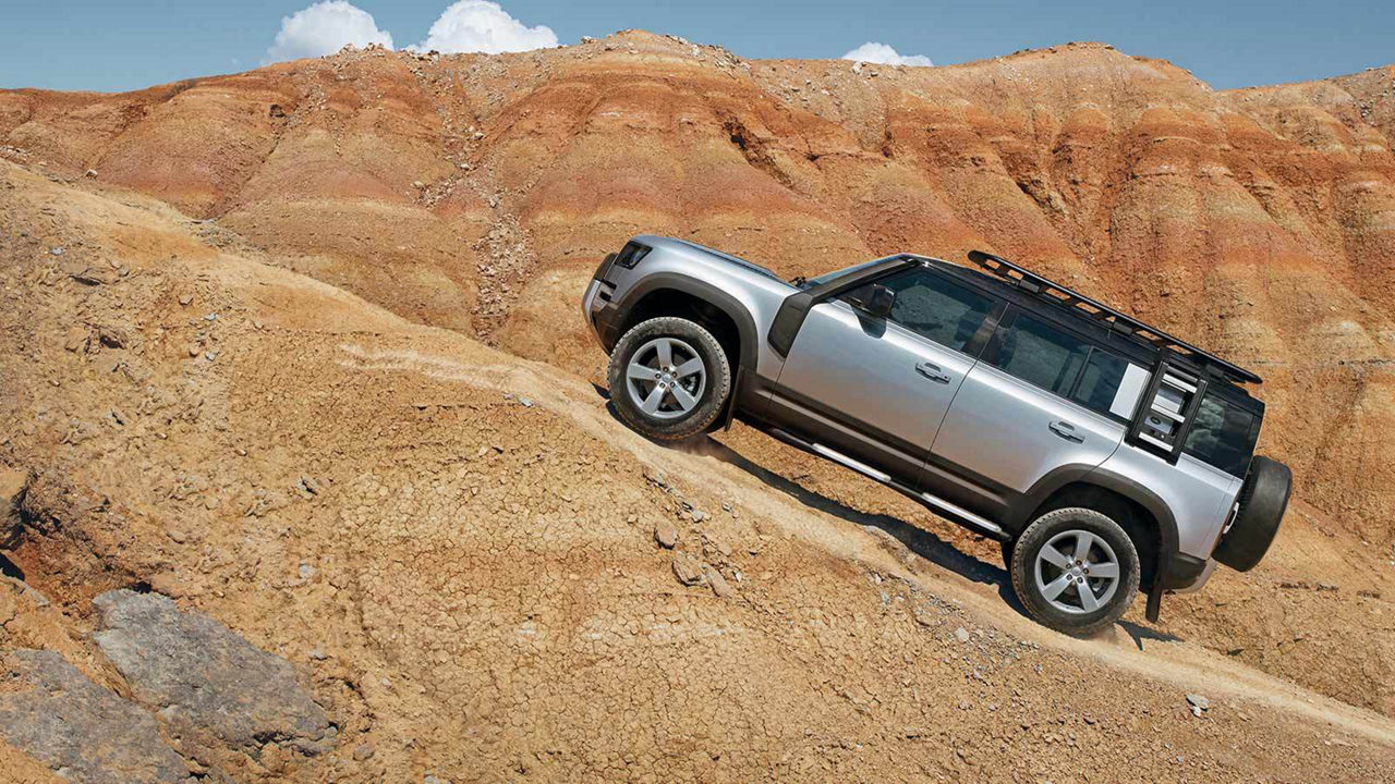 Land Rover Defender parked on a rocky hill