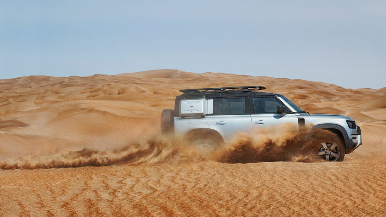 Land Rover Defender driving in sand