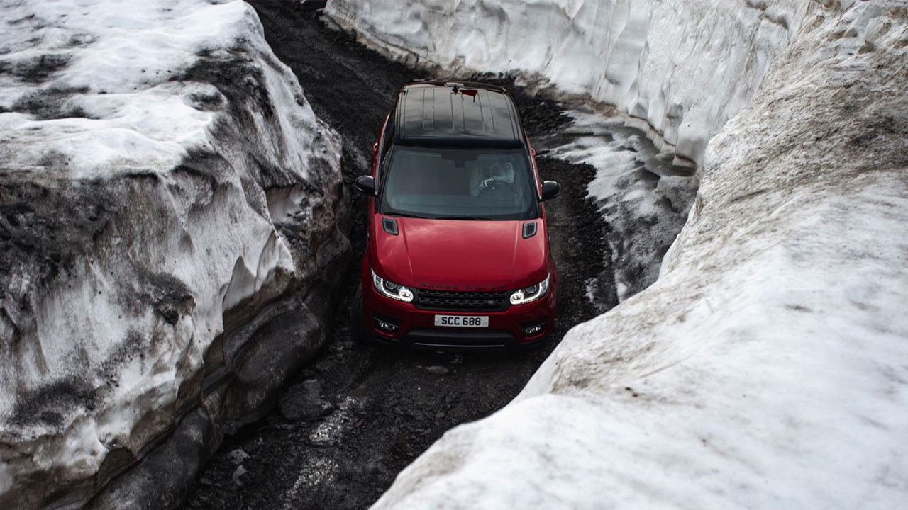 Range Rover in red driving in ice landscape