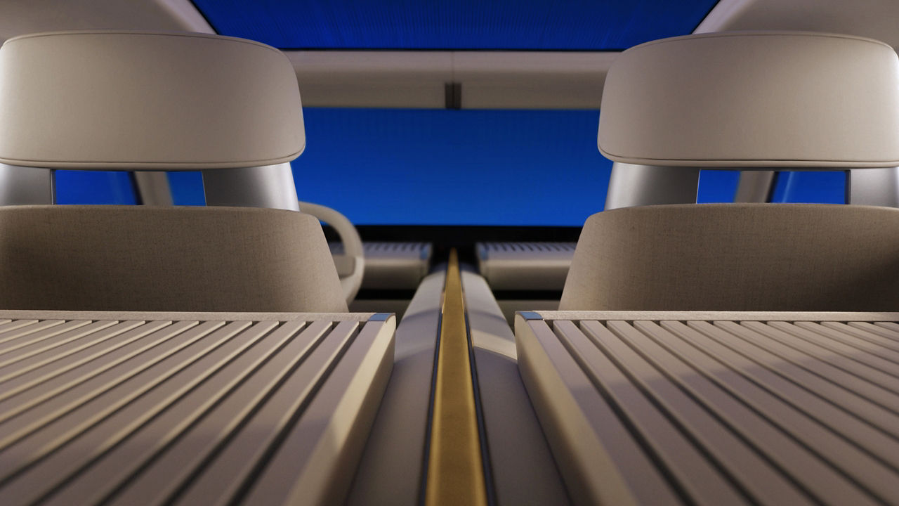 Interior view of a car showing seats and a wooden center console with a blue background.