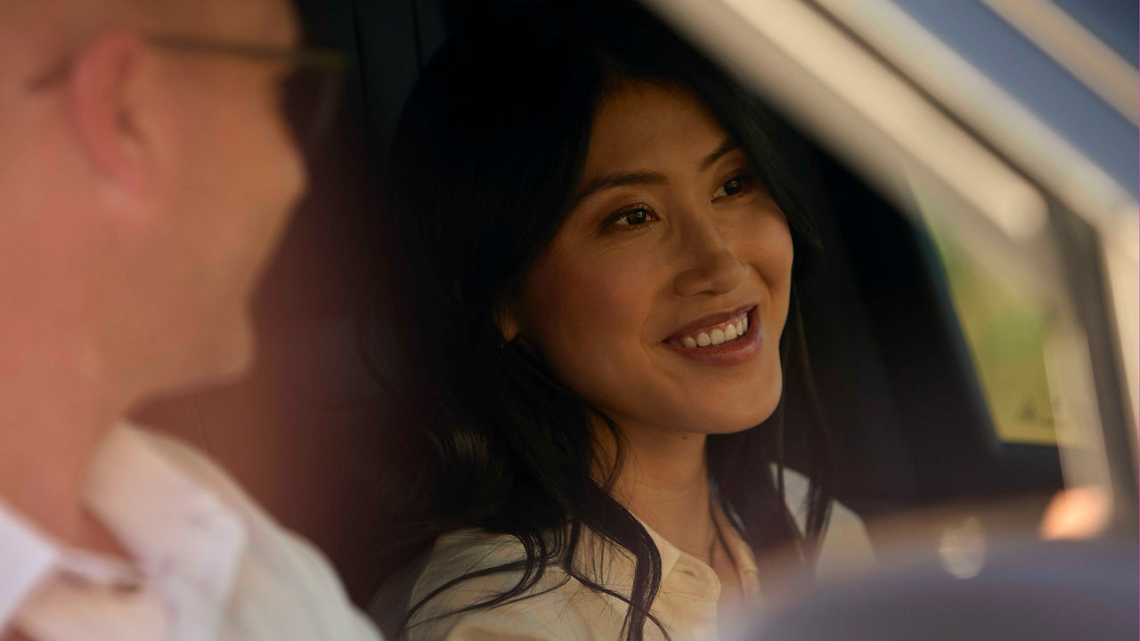 A woman smiling while sitting in a Range Rover.