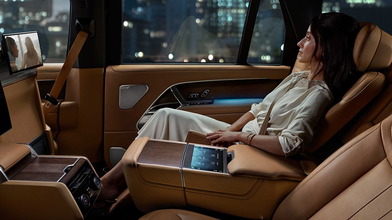 Woman reclined in the New Range Rover watching TV