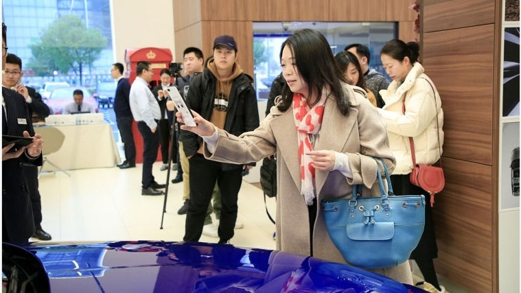 Woman taking a photo of a Jaguar Vehicle 