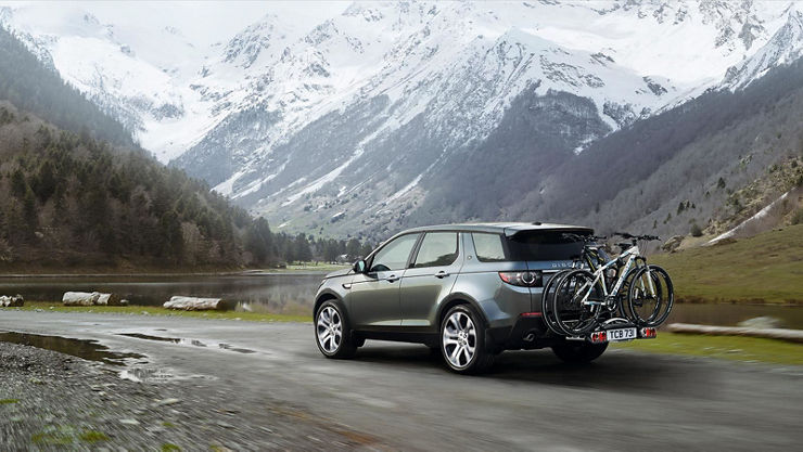 Land Rover Discovery with bicycle rack driving on mountain road