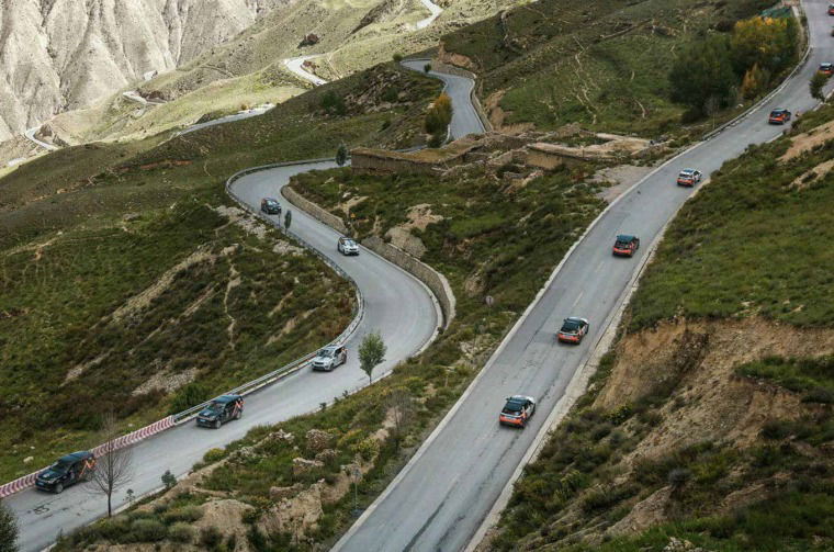 Land Rover vehicles driving on winding mountain road