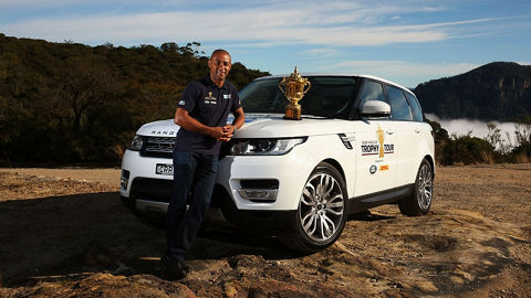 Man leaning on Range Rover with Rugby World Cup trophy