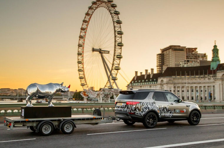 Land Rover Discovery pulling trailer with Land Rover Rhino sculpture