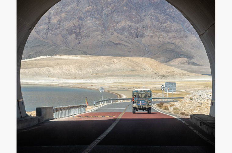Land Rover Series I driving through tunnel in mountain landscape
