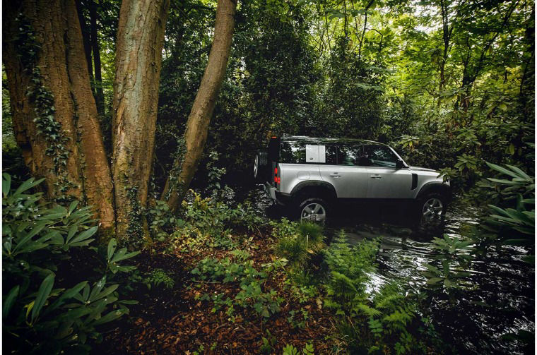 Range Rover Defender driving in a river
