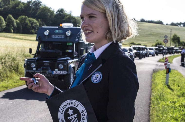 A woman with a tally counter as the Land Rover parade goes by