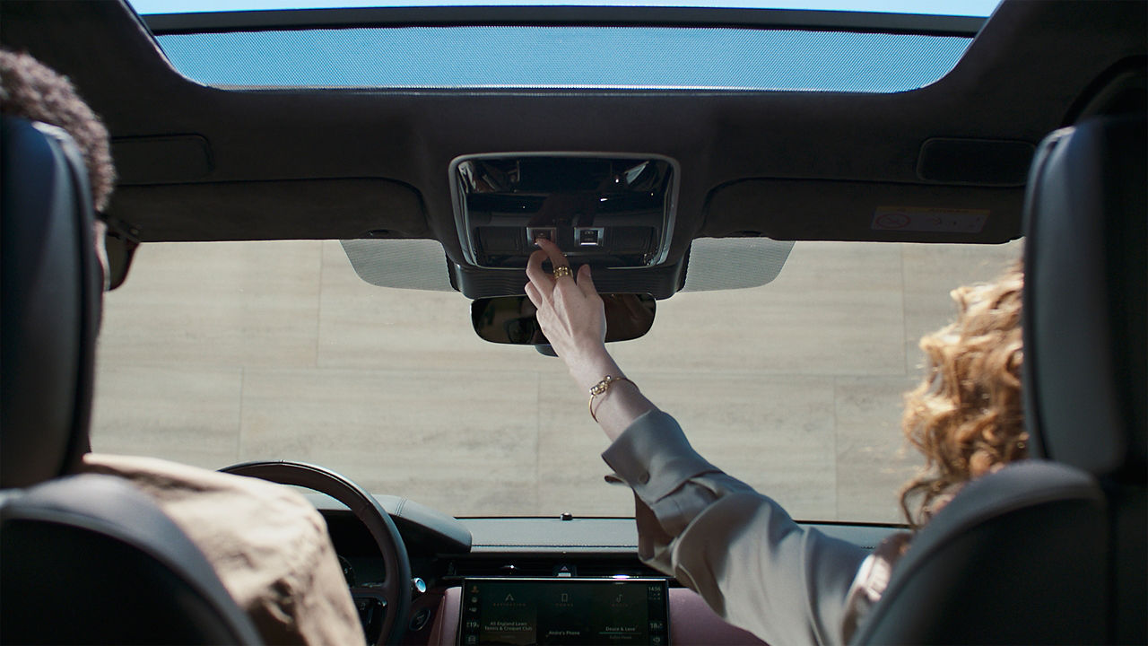 Woman operating the sliding panoramic roof