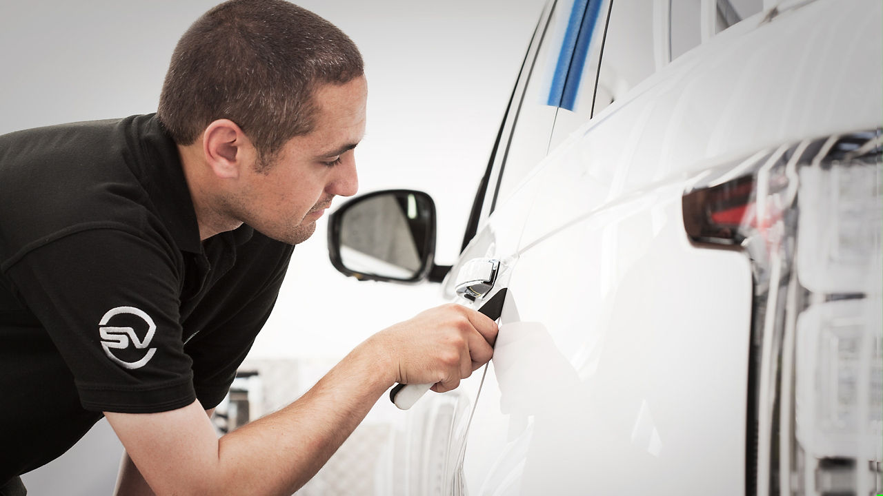 Range Rover car detailing and hands of professional car service male worker