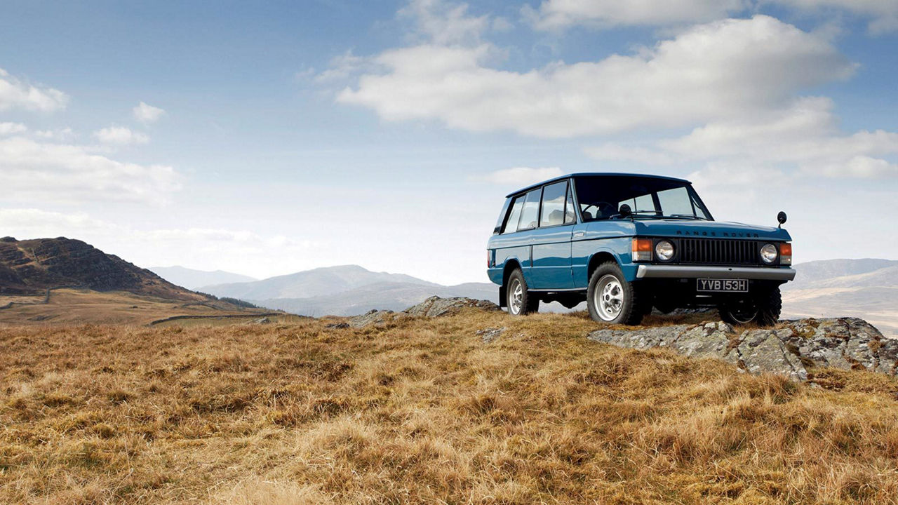 Blue Range Rover by the hill